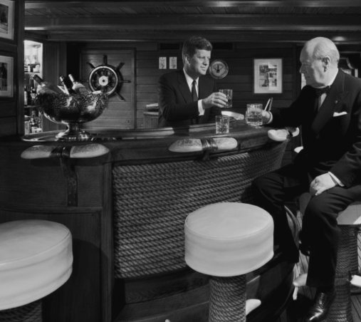 Two men in evening dress at the bar aboard CHRISTINA