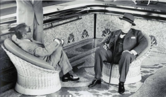 Two men in wicker chairs beside the mosaic pool aboard CHRISTINA