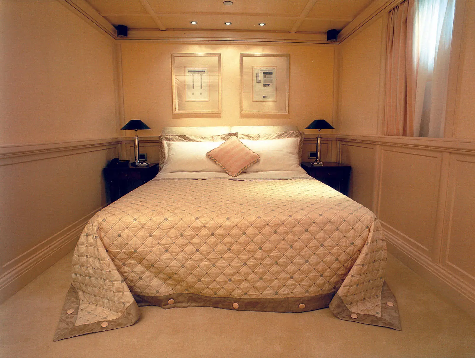 Guest cabin aboard CHRISTINA O with double bed and paired bedside lamps