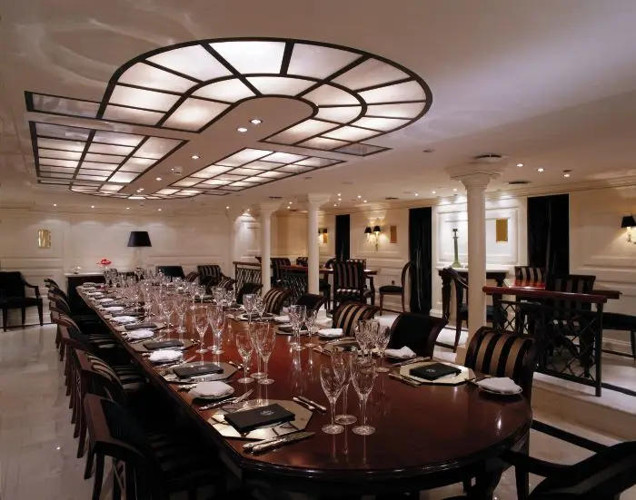 Formal dining saloon aboard CHRISTINA O with mahogany table and columns