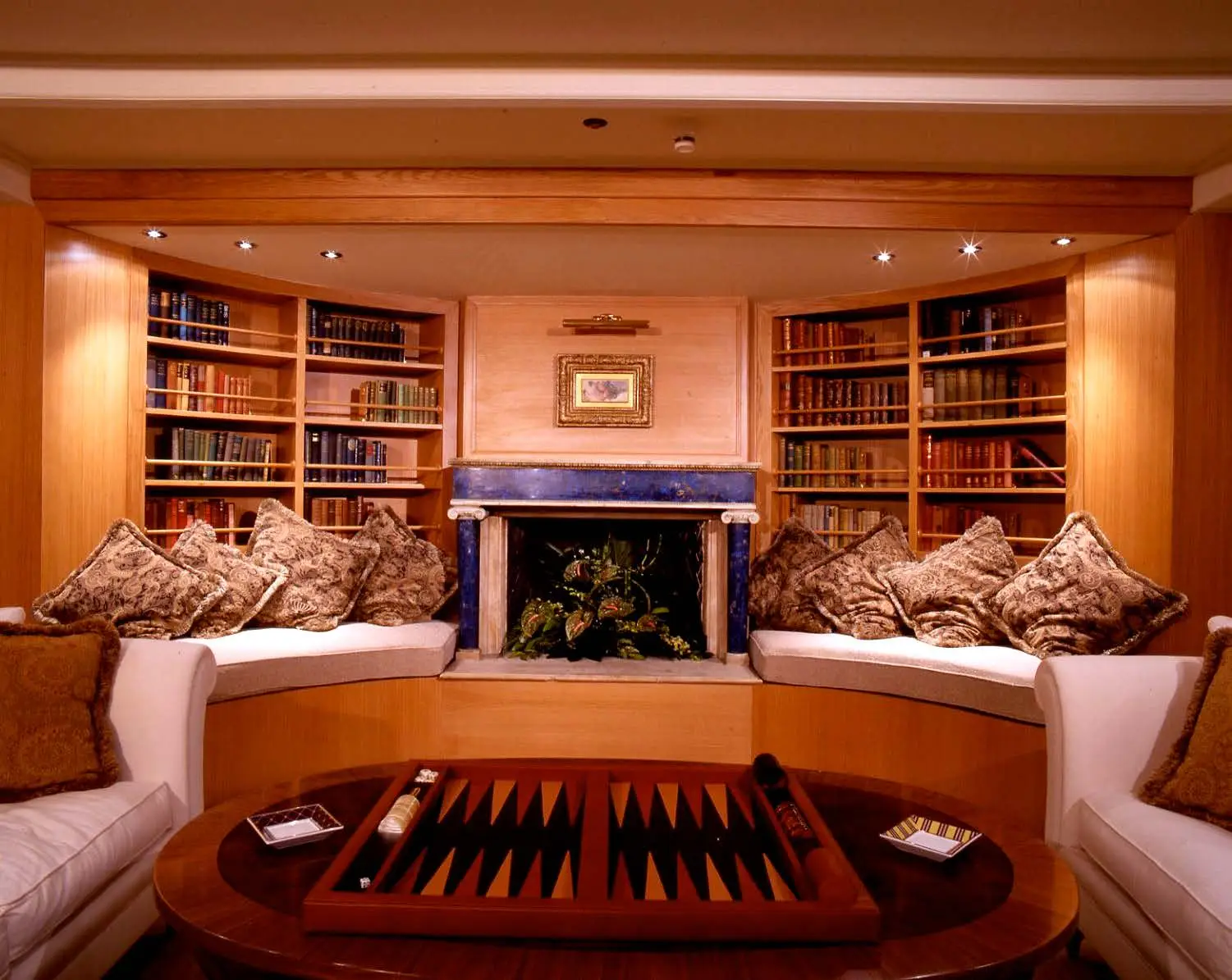 Library aboard CHRISTINA O with lapis fireplace surround and bookshelves